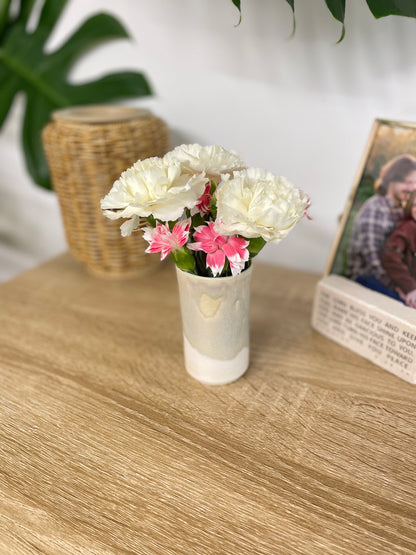 Light sage green and eggshell colored small ceramic bud vase holding white and pink flowers