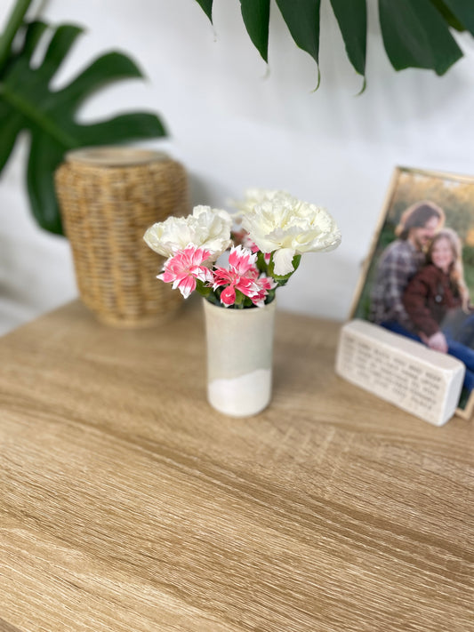 Light sage green and eggshell colored small ceramic bud vase holding white and pink flowers