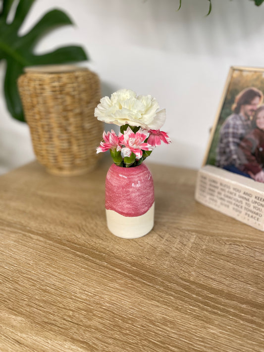 Hot pink colored small ceramic bud vase holding pink and white flowers
