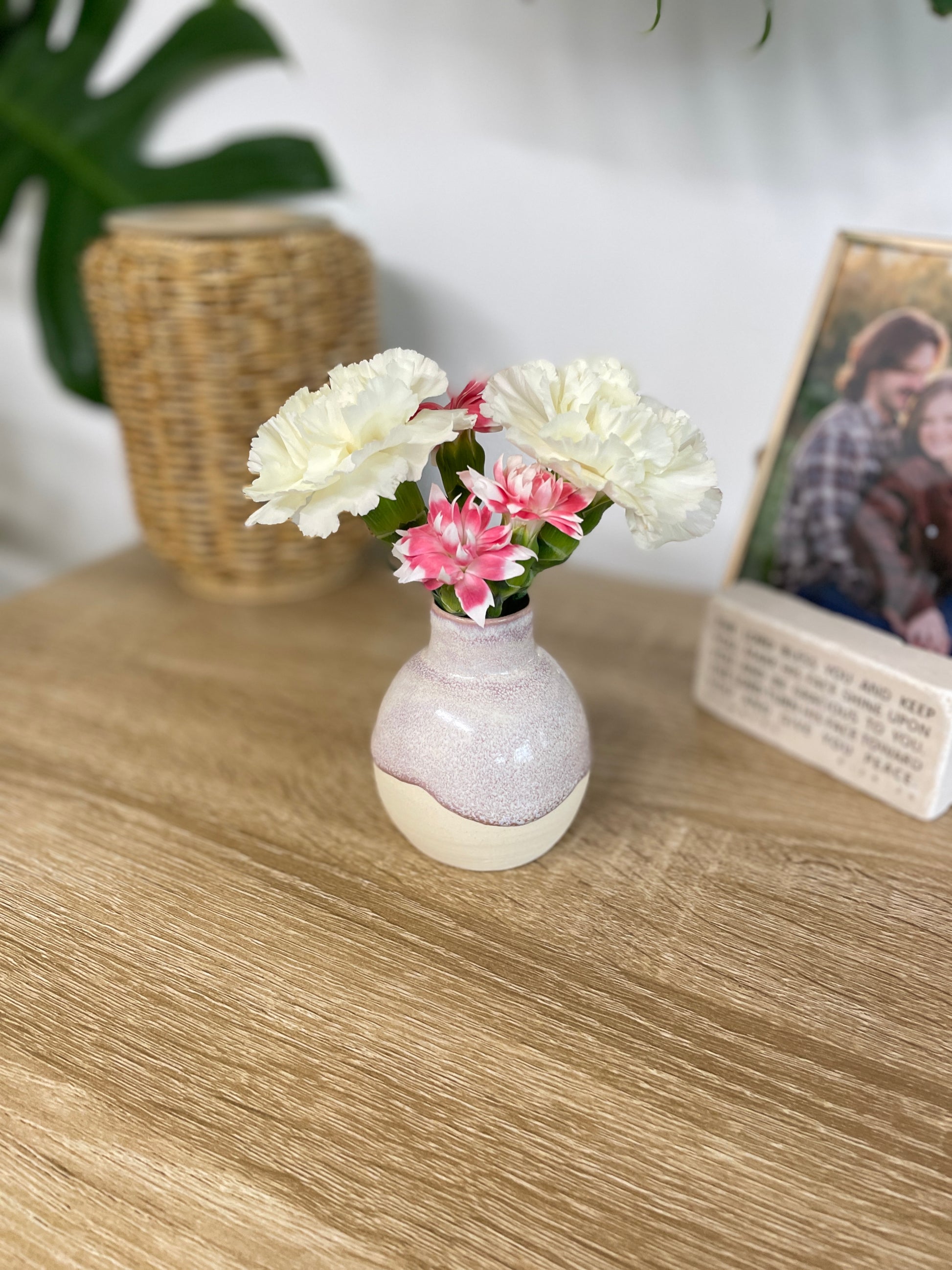 Hazy lavender colored small ceramic bud vase holding pink and white flowers