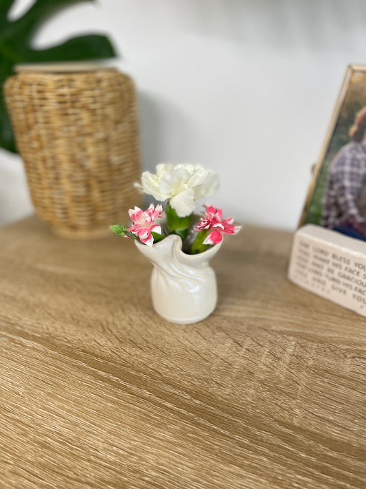 Eggshell colored small ceramic bud vase holding white and pink flowers